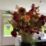 Decoratief bloemstuk in vaas in de kleuren rood en oranje