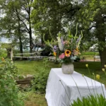 Bruidsornament in een vaas op een wit tafelkleed buiten in de natuur