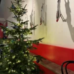 Rode bank met kerstboom en decoratieve geslachte kalkoenen aan de muur