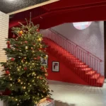 Prachtig rode inrichting van een bedrijfsruimte met een kerstboom met rode en gouden ornamenten